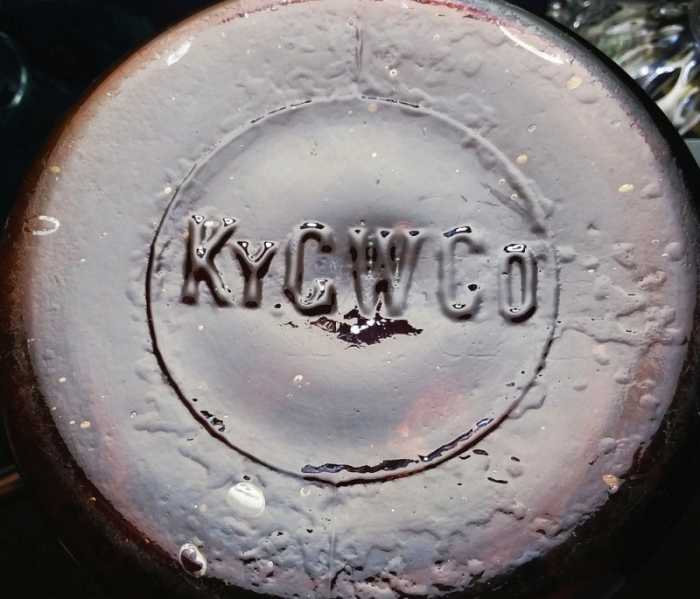 KY.G.W.Co. mark on base of dark amber half-gallon wax sealer jar. KY.G.W.Co. mark on base of dark amber half-gallon wax sealer jar.