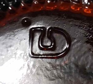 "Stylized D" mark used by DOMGLAS - here on base of small amber bottle made for Kitchen Bouquet culinary sauce