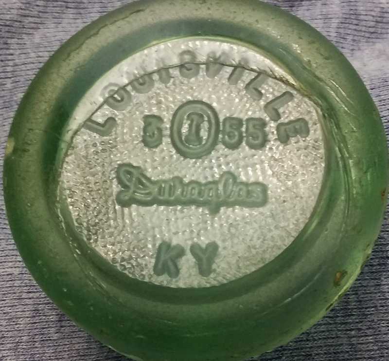 Owens-Illinois Glass Co - light green soda bottle base - marked "Duraglas" and Louisville, KY - the base bears a 1955 date code.  "I inside an O" was the company trademark at the time.  The "3" indicates the bottle was made at their Fairmont, WV factory.   The circular line or crease  is an "Owens Scar" - made during manufacture - partially distorting the LOUISVILLE embossing. 