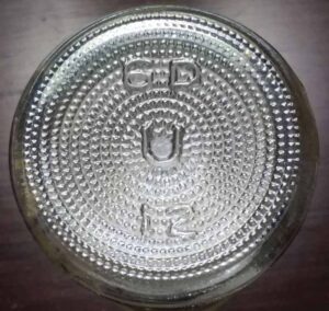 "U" mark on base of BAUMER FOODS, INC. marked clear glass bottle that contained Crystal Hot Sauce - bottle made by Underwood Glass Company, New Orleans, LA.