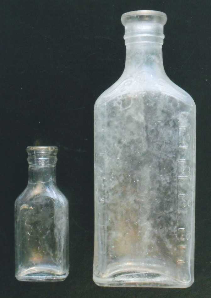 Two clear glass druggist / prescription bottles, both marked "LYRIC" on the base, made by Illinois Glass Company based in Alton, Illinois.
