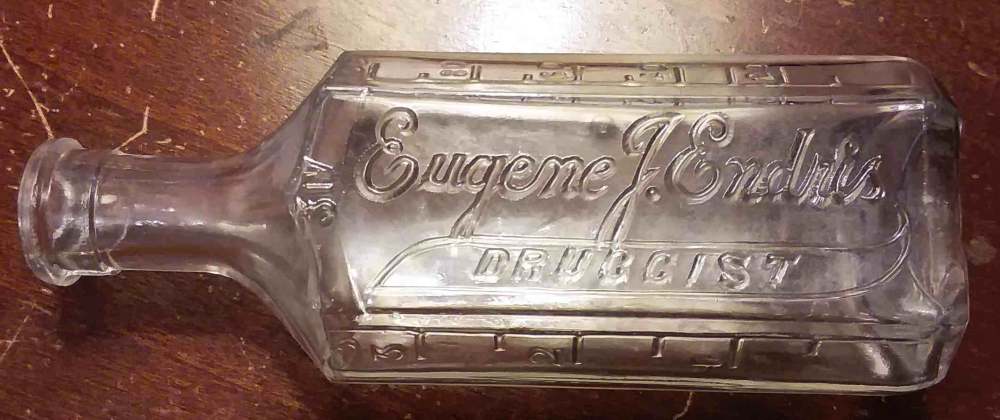 "Eugene J. Endris" glass druggist bottle, probably from the 1910s.  Although the city and state is not included on the bottle, this was a druggist located in New Albany, Indiana.  This is just one example of the many thousands of druggists who had customized prescription bottles produced for their business - this practice was most common in the 1870s-1920s period.  This particular bottle is not marked with a glassmaker mark on the base, so the actual glass manufacturer is unknown. 