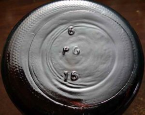 "P G" mark on base of modern amber glass 16 ounce "Boston Round" chemical bottle. The "P G" almost certainly stands for a glassmaker or container distributor. The bottle likely dates after around 1990. Do you know what this mark stands for? 