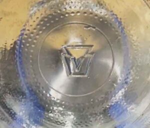 "V in a keystone" mark on base of clear glass gallon jug (Photo courtesy of Ryan Thomas).