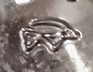 Unidentified glassmaker mark seen on clear glass vase or bottle, Stylized gazelle? Two triangles? W mark? Info needed! (Photo courtesy of Mary Bonevelle).