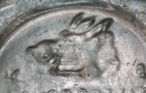"Boar's Head" trademark emblem on colorless glass bottle base - from a Gordon's Dry Gin bottle 