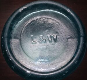 "L & W" - Lorenz & Wightman, Pittsburgh, PA. As it appears on base of blue-aqua "H. Schuckman - Louisville KY" mineral water bottle. "L & W" - Lorenz & Wightman, Pittsburgh, PA. As it appears on base of H. Schuckman - Louisville KY mineral water bottle.
