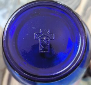 "Cross" emblem on base of cobalt blue globular miniature lamp, probably made in Hong Kong. (Photo courtesy of Heidi Venture) 