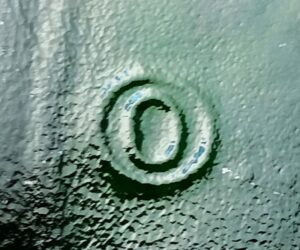 "O inside an O". This mark as seen on the bottom of a green Jagermeister bottle.