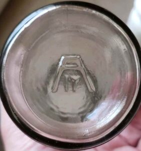 "Stylized A" or "Sawhorse" mark with "IT" placed below, shown here on base of clear ketchup bottle. (Photo courtesy of Robert Maldonato). 