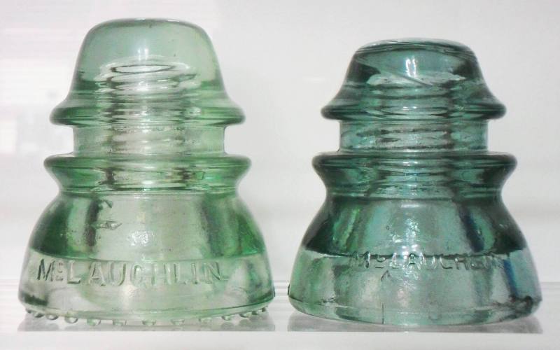 Two CD 154 "McLAUGHLIN / NO. 42" variants. The light green example on left has round drip points, the sage-gray green insulator on right has a smooth base. This style was a competitor to the ubiquitous "HEMINGRAY-42" made by Hemingray Glass Company. Two CD 154 "McLAUGHLIN / NO. 42" variants. The light green example on left has round drip points, the sage-gray green insulator on right has a smooth base. This style was a competitor to the ubiquitous "HEMINGRAY-42" made by Hemingray Glass Company.