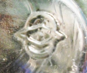 Diamond and oval trademark used by Owens Illinois Glass Company. The oval on this example is comparatively larger than the diamond, and more "vertically oriented" here than on most typical O-I bottles. This characteristic may have been more common on some of the the earlier bottle molds (c. very early 1930s). Diamond and oval trademark used by Owens Illinois Glass Company. The oval on this example is comparatively larger than the diamond, and more "vertically oriented" here than on most typical O-I bottles. This characteristic may have been more common on some of the the earlier bottle molds (c. very early 1930s).