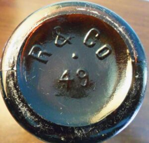 "R & CO / 49" marking on amber beer bottle base - this bottle was made by Reed & Company of Massillon, Ohio "R & CO / 49" marking on amber beer bottle base - this bottle was made by Reed & Company of Massillon, Ohio
