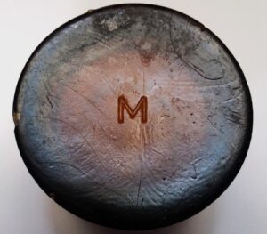 M" on base of amber salve jar, circa 1880 - 1910. Maker is uncertain, but possibly either Massillon Glass Works or Modes Glass Company. "M" on base of amber salve jar, probably circa 1880- 1910. Maker is uncertain, but possibly either Massillon Glass Works or Modes Glass Company.